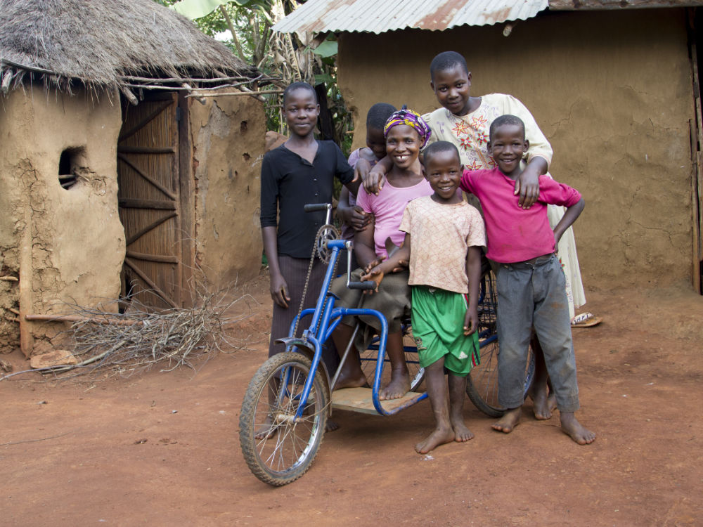 Woman on a hand bike surrounded by her five children